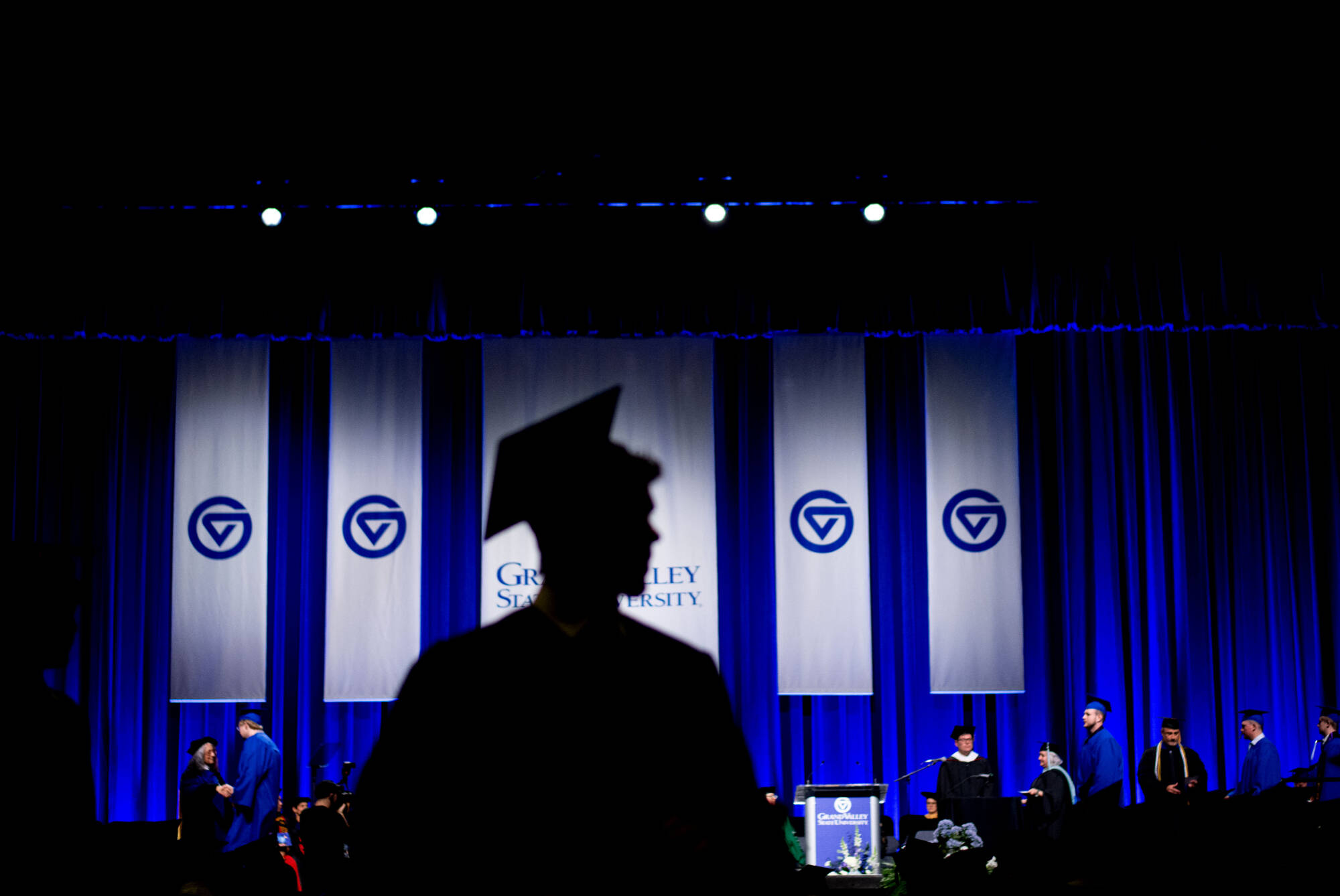 Silhouette of a GVSU graduate at commencement.